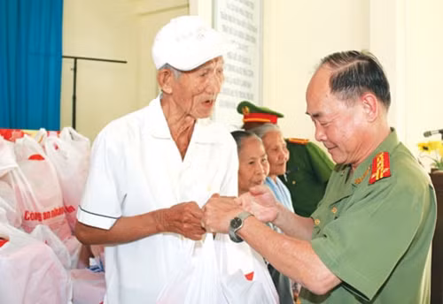 Đại tá Trần Kim Thẩm, Phó Tổng biên tập Báo CAND trao quà Tết cho bà con nghèo huyện Cai Lậy, tỉnh Tiền Giang. (Ảnh: Văn Đức )