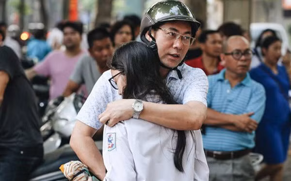 Một ông bố ôm con an ủi sau khi làm bài thi. Ảnh kênh 14.vn