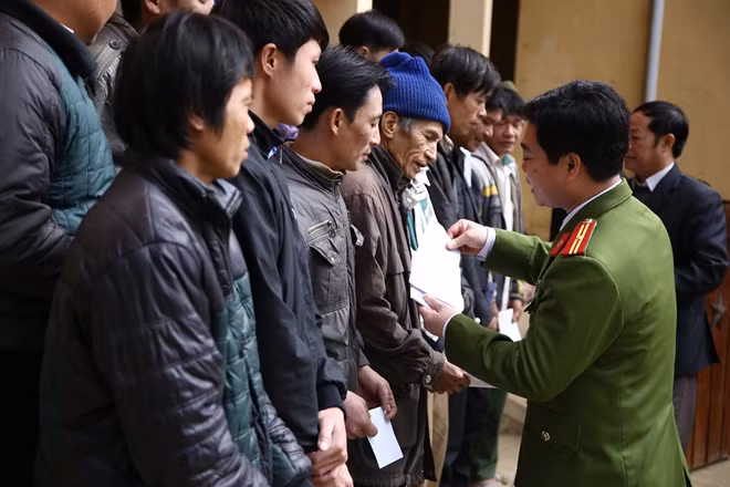 Thiếu tá Trần Quốc Hoàn, Phó trưởng Công an huyện Tân Lạc trao quà Tết cho người dân