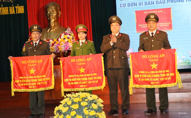 Đại tá Nguyễn Hải Trung, Phó Tổng cục trưởng Tổng cục Chính trị CAND trao Cờ thi đua của Bộ Công an cho các đơn vị.