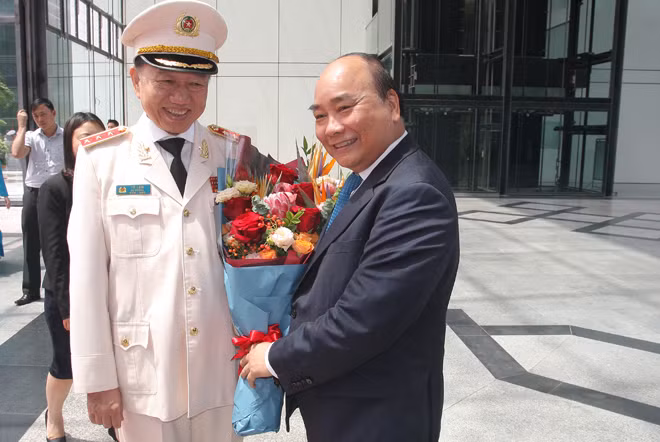 Bộ trưởng Tô Lâm tặng hoa chúc mừng Thủ tướng Nguyễn Xuân Phúc.