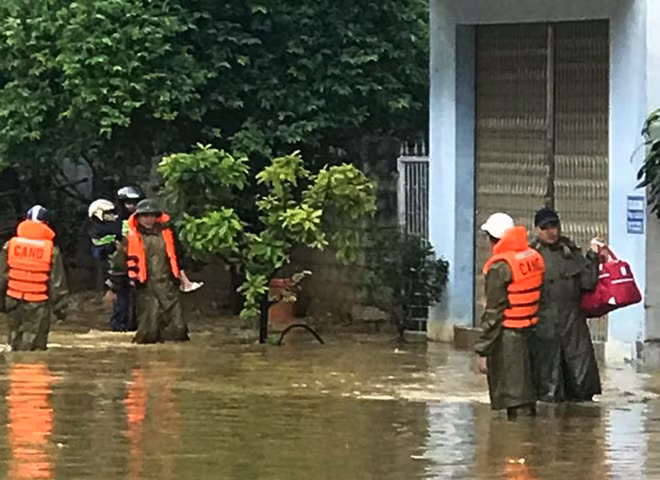 CBCS Công an huyện Mai Châu, Hòa Bình cõng trẻ em và di chuyển đồ đạc cho hành khách bị kẹt tại do ngập nước tại ngã ba Tòng Đậu.
