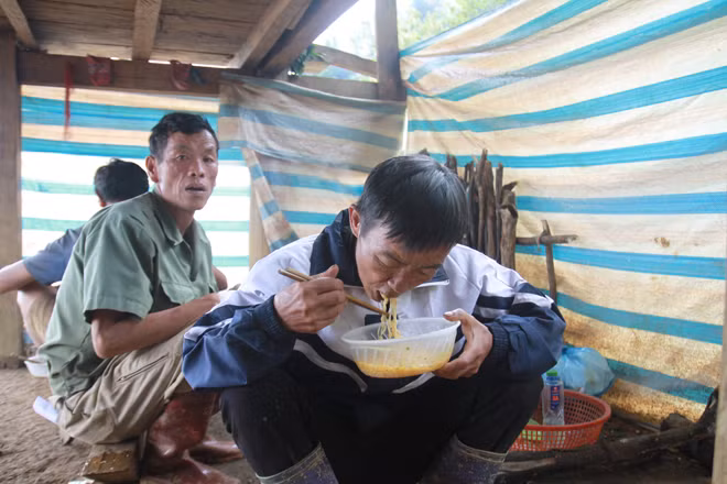 Người dân ăn vội bát mì do đoàn cứu trợ đưa đến.