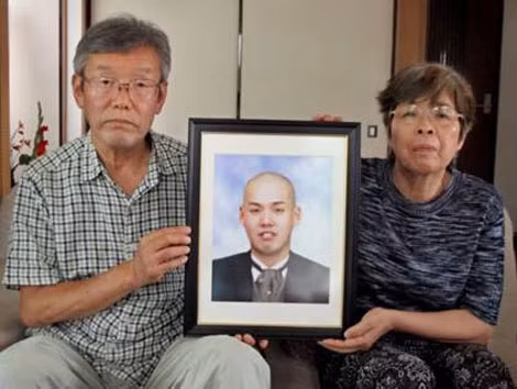 Cha mẹ của Kiyotaska Serizawa cầm di ảnh con trai.