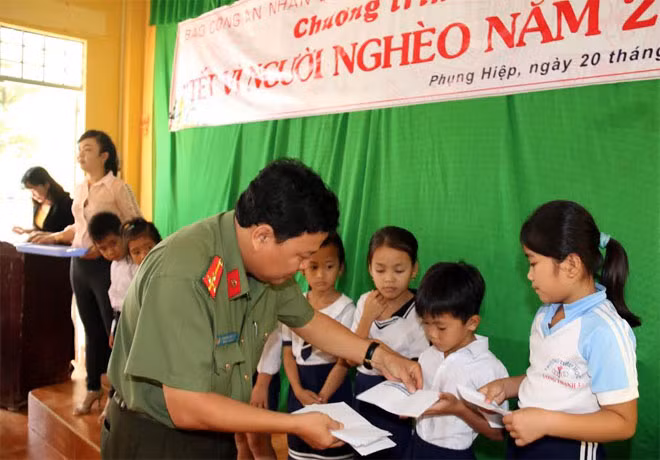 Đại diện Báo CAND trao quà cho học sinh nghèo.