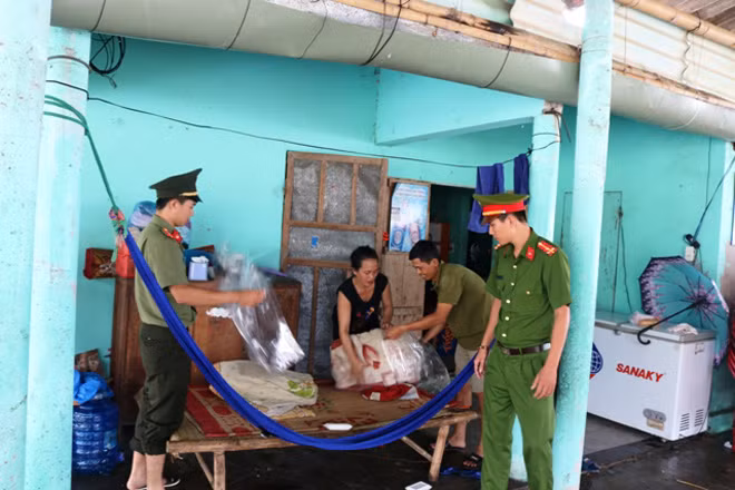 Cán bộ chiến sĩ Công an Quảng Bình giúp dân thu dọn đồ dùng sinh hoạt để chuẩn bị sơ tán tránh bão.