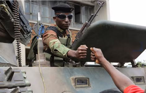 Một binh sĩ quân đội Zimbabwe cụng tay với một người biểu tình để tỏ thái độ vui mừng khi ông Mugabe từ chức. Một binh sĩ quân đội Zimbabwe cụng tay với một người biểu tình để tỏ thái độ vui mừng khi ông Mugabe từ chức.