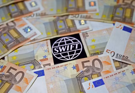 Logo SWIFT nằm giữa những tờ giấy bạc Euro.