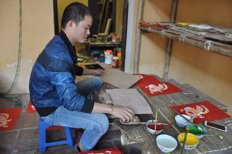 Nghệ nhân trẻ người làng Kim Hoàng - Đào Đình Trung miệt mài làm tranh cho kịp phục vụ mùa tranh Tết 2017.