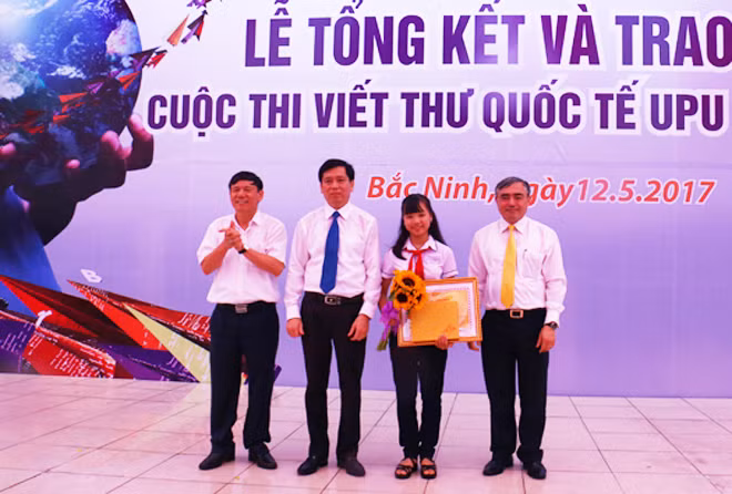 Ban tổ chức trao giải nhất cuộc thi viết thư quốc tế UPU lần thứ 46 cho học sinh Nguyễn Đỗ Huyền Vi.