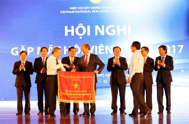Thứ trưởng Bộ Xây dựng Bùi Phạm Khánh trao cờ thi đua của Chính phủ cho Chủ tịch Hiệp hội BĐS Việt Nam).