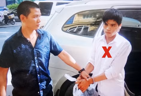 Trung tá Trần Nhật Tân dẫn giải một đối tượng truy nã (dấu X). Trung tá Trần Nhật Tân dẫn giải một đối tượng truy nã (dấu X).