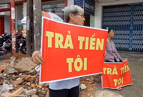 Người dân đưa băng rôn đòi tiền.