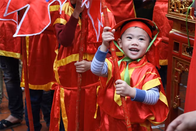 Không chỉ người lớn, những em nhỏ trong làng cũng được hóa anh lính hòa vào dòng người rước kiệu.