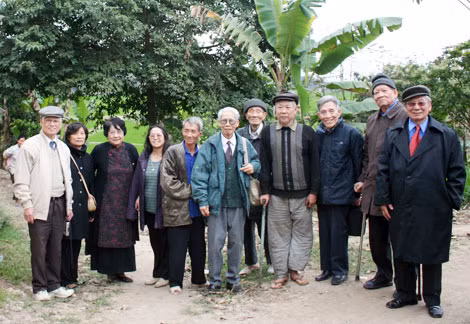 Các cựu học viên Trường Ngoại ngữ Việt Bắc và thân nhân cụ Chu Văn Mão bên gốc cây thị năm xưa.