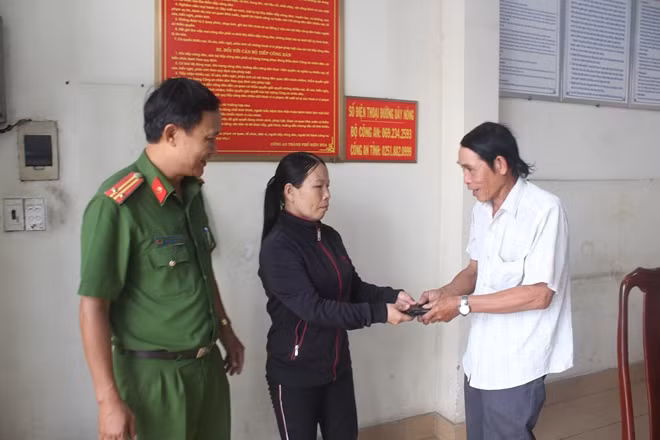 Chị hậu bàn giao lại chiếc ví cho chủ nhân tại công an phường.