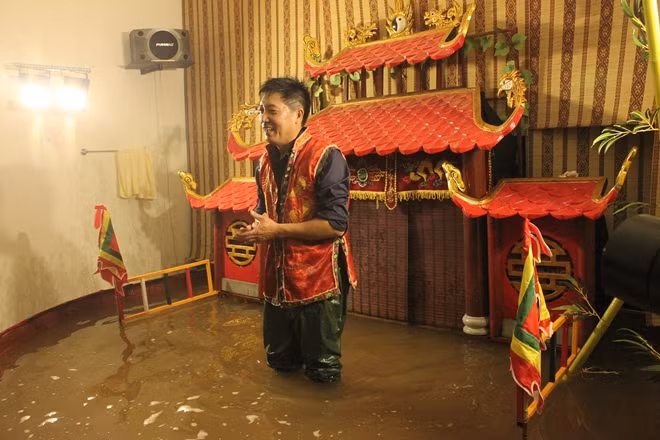 Nghệ nhân Phan Thanh Liêm trên sân khấu múa rối nước thu nhỏ do anh thành lập