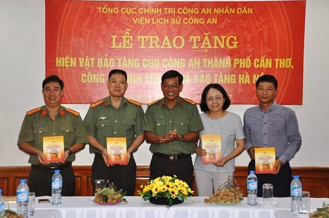 Các đại biểu tiếp nhận tập kỷ yếu lịch sử của các liệt sĩ, thương binh CAND do Viện Lịch sử CAND trao tặng
