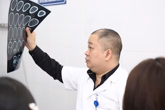 TS Nguyễn Anh Tuấn đang xem phim chụp não cho bệnh nhân