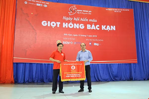 Ông Phạm Duy Hưng (áo đỏ), Phó Chủ tịch UBND tỉnh Bắc Kạn nhận cờ lưu niệm Hành trình Đỏ