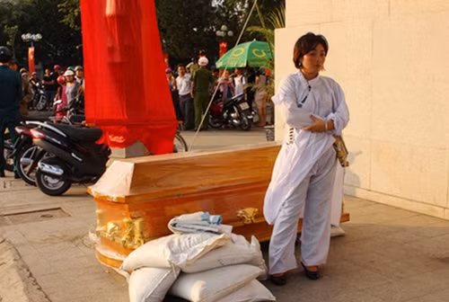 Người phụ nữ đưa quan tài đến cửa ngân hàng.