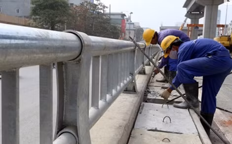 Phía ngoài, cạnh hai bên lan can hầm là rãnh thoát nước đang được công nhân lắp đặt.