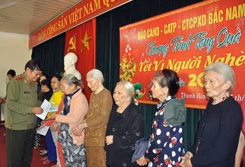 Trung tướng Lê Ngọc Nam, nguyên Phó Tổng cục trưởng Tổng cục Chính trị CAND tặng quà các hộ nghèo.