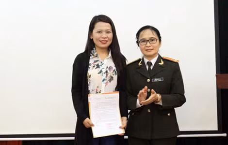Trung tá Đỗ Hoàng Anh, Chủ tịch Công đoàn Báo CAND trao quyết định kết nạp đoàn viên công đoàn mới.