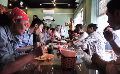 Sau buổi làm việc vất vả, những người lao động nghèo ngồi quây quần bên nhau ăn bữa cơm trưa đầy tình người với giá 1000 đồng/1 suất - Ảnh: Thanh Xuân.