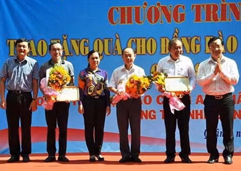 Đồng chí Trương Hòa Bình cùng đại diện đoàn công tác xã hội từ thiện báo CAND nhận hoa và thư cảm ơn của địa phương.