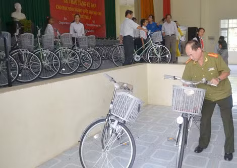 Đại tá Trần Kim Thẩm - Phó Tổng Biên tập báo CAND ân cần đưa xe đạp ra ngoài khi nhiều học sinh vẫn còn bỡ ngỡ.