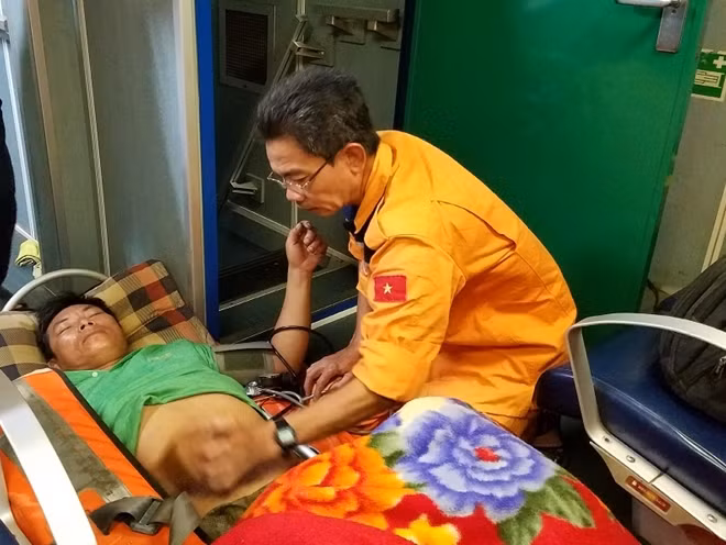 Ngư dân Mai Văn Hoàng được thăm khám ban đầu ngay trên tàu cứu hộ