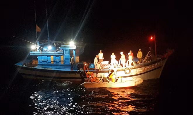 Lực lượng cứu hộ dùng xuồng cao su đón các thuyền viên từ tàu bị nạn để chuyển sang tàu SAR 412