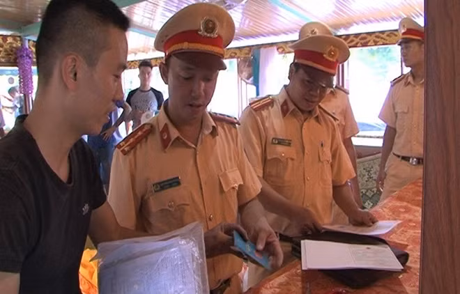 Lực lượng phòng CSGT Công an tỉnh Thừa Thiên Huế kiểm tra hành chính một phương tiện thuyền rồng chở du khách tham gia lễ hội Điện Huệ Nam.