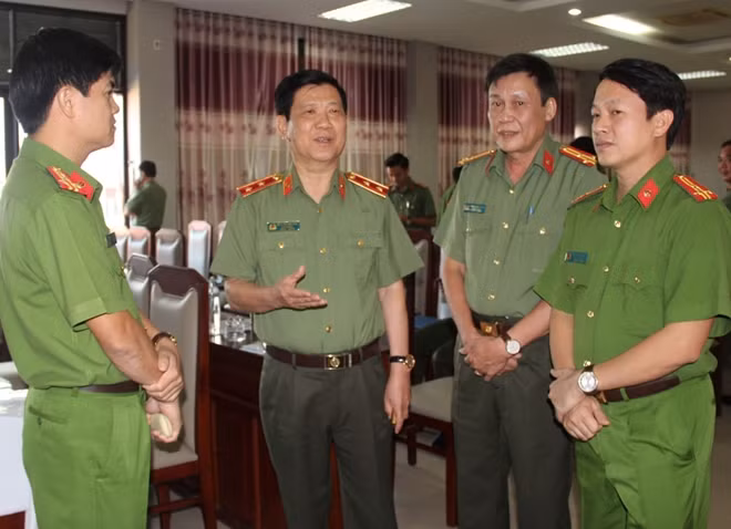 Trung tướng Nguyễn Văn Sơn, Thứ trưởng Bộ Công an trao đổi cùng các đại biểu dự hội nghị.