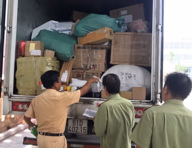 Nhiều bao tải, thùng các tông chứa các mặt hàng lậu được chất sau thùng xe tải.