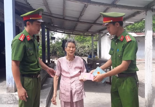 Người dân vui mừng khi nhận giấy CMND, sổ hộ khẩu vừa được cán bộ Công an giúp đỡ cấp đổi.
