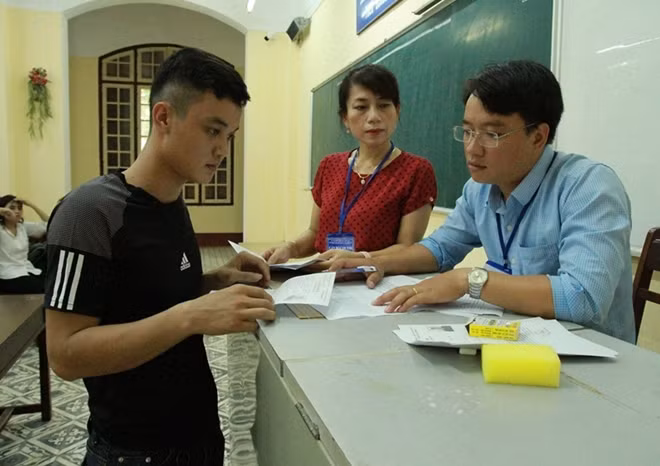 Cán bộ coi thi đối chiếu thông tin cá nhân của thí sinh.