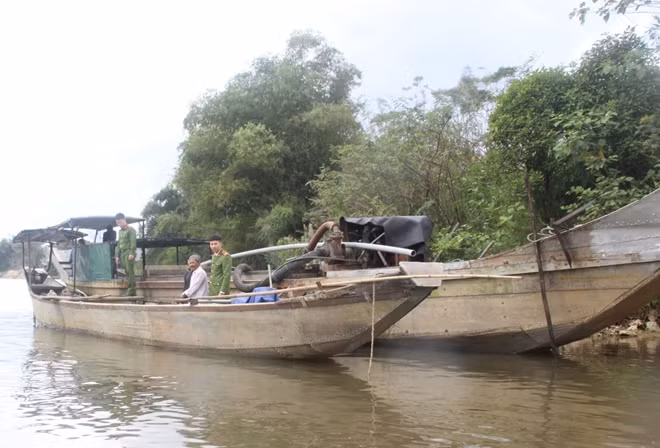 Các phương tiện dùng vòi rồng để hút cát trái phép trên sông Bồ.