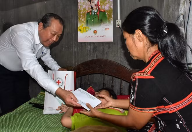 Phó Thủ tướng Thường trực Trương Hòa Bình tặng quà và ân cần thăm hỏi, động viên các gia đình có con em bị di nhiễm chất độc da cam ở huyện A Lưới, tỉnh Thừa Thiên Huế.