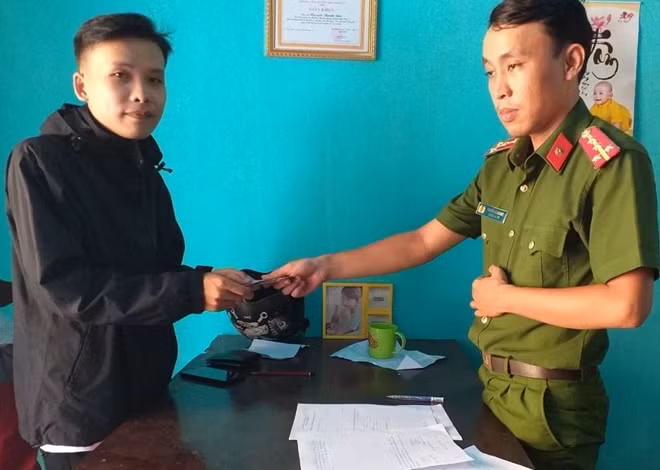 Đại úy Nguyễn Lê Anh Đức trao trả số tiền nhặt được cho anh Ngô Quang Trường.