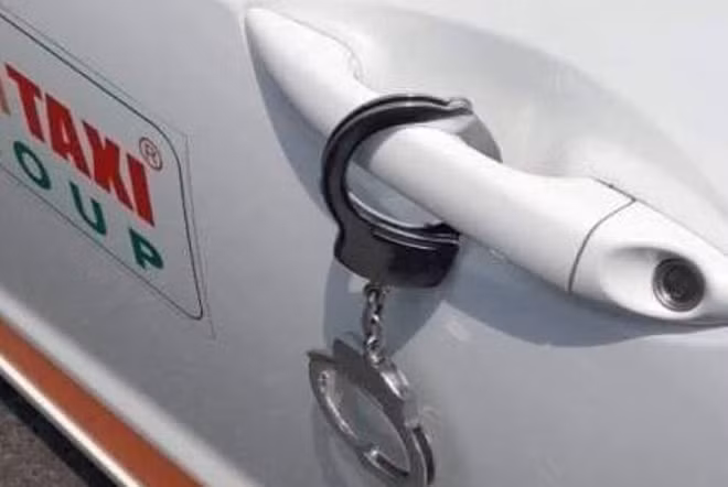 Hai bảo vệ Nhân và Long dùng còng số 8 buộc ghế nhựa vào cửa xe taxi do chị Băng điều khiển.