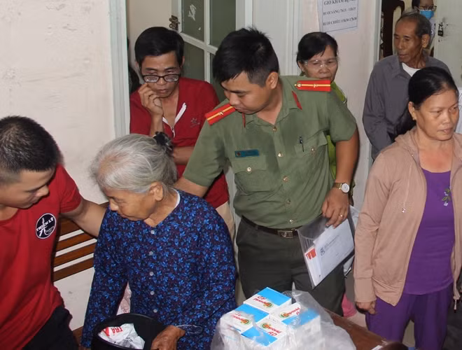 Sau khi bác sĩ khám mắt, cụ bà được CBCS Công an giúp tìm chỗ ngồi để đợi đến lượt nhận thuốc điều trị.