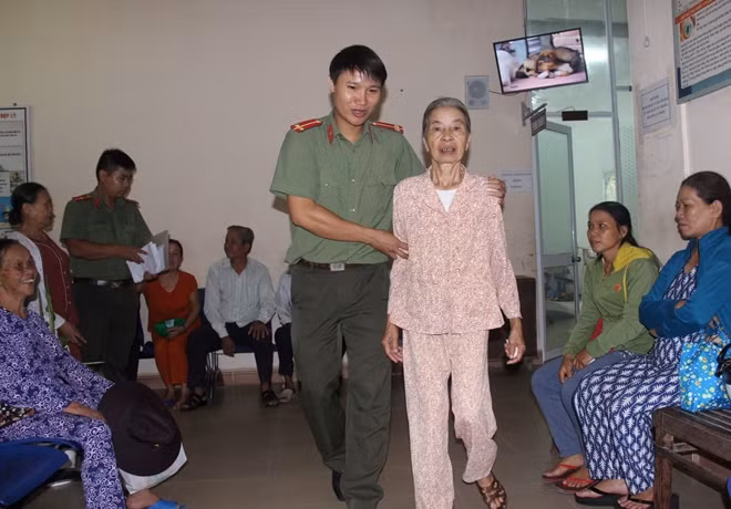 Tận tình giúp đỡ cụ bà đi lại khó khăn đến khám bệnh mắt.