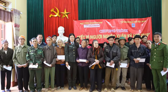 Thiếu tá Cao Thị Hồng, Phó trưởng Ban Kinh tế - Pháp luật, Báo CAND cùng đại diện Công an huyện Trấn Yên (Yên Bái) trao quà Tết tới đồng bào nghèo xã Lương Thịnh.