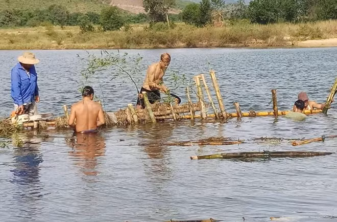 Người dân phường Hương Vân tháo dỡ hàng rào cọc tre trên sông Bồ.