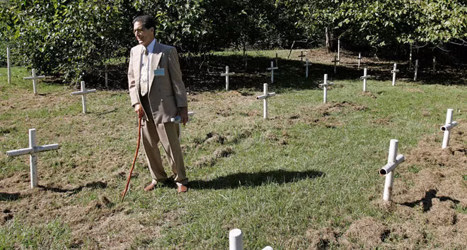 Dick Colon, một trong những nạn nhân của “Nhà Trắng” đi bộ qua các khu mộ gần Trường Dozier, Florida.