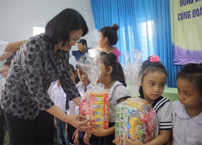Đồng chí Phó Chủ tịch nước Đặng Thị Ngọc Thịnh tặng quà cho các em học sinh.