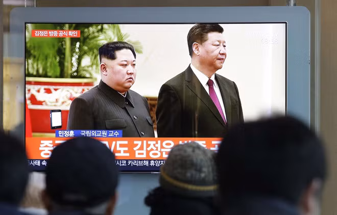 Hình ảnh cuộc gặp giữa nhà lãnh đạo Triều Tiên Kim Jong-un và Chủ tịch Trung Quốc Tập Cận Bình ngày 8-1 trên truyền hình Hàn Quốc.