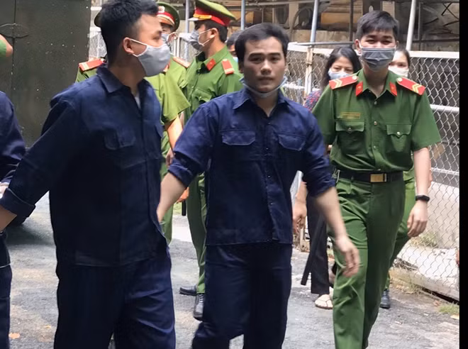 Bị cáo Bảo (bên trái) và Phú dời tòa sau phiên xử